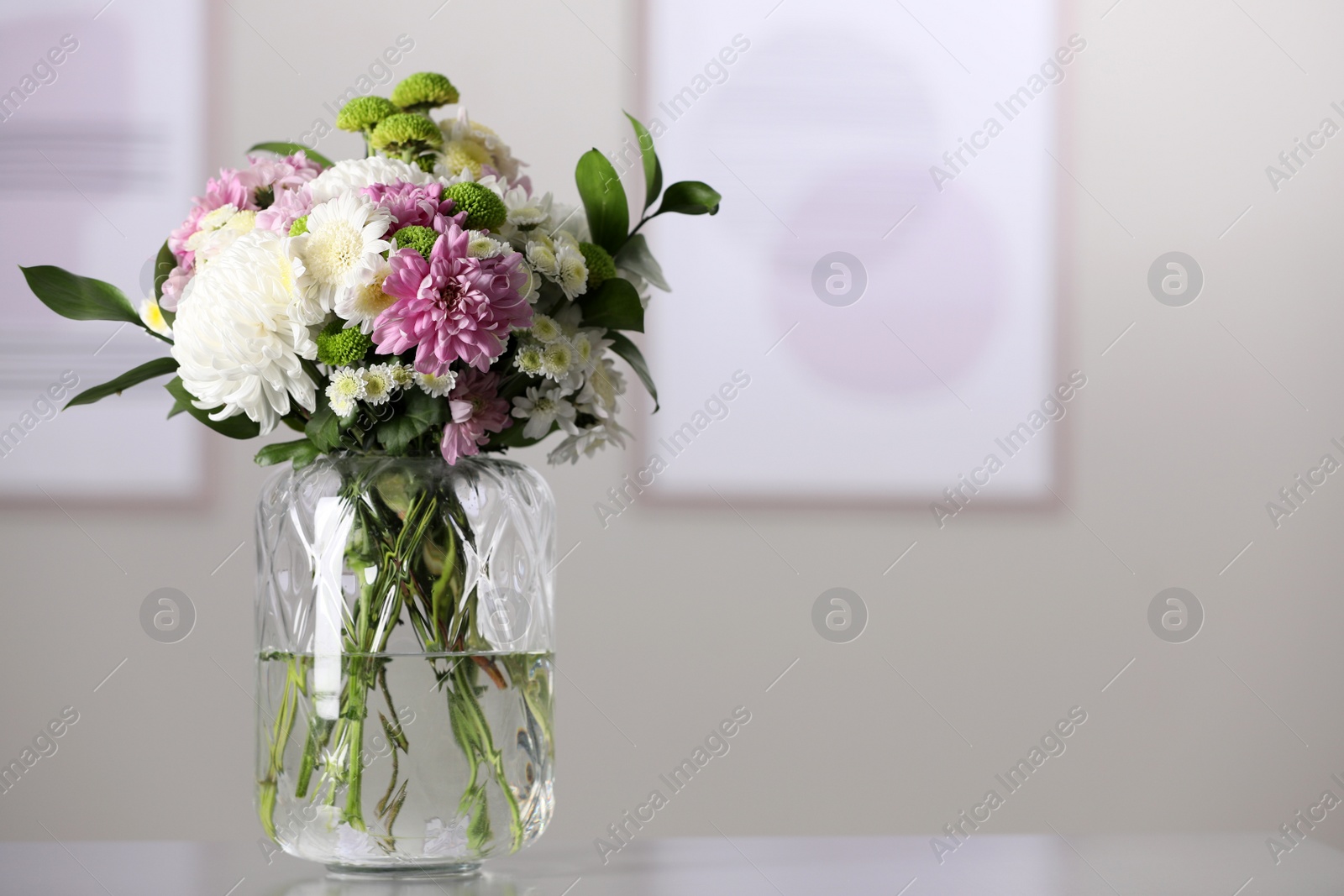 Photo of Bouquet of beautiful chrysanthemum flowers on table in room, space for text