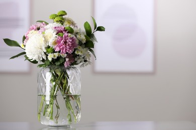 Photo of Bouquet of beautiful chrysanthemum flowers on table in room, space for text