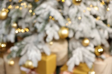 Blurred view of Christmas tree with baubles, lights and gift boxes