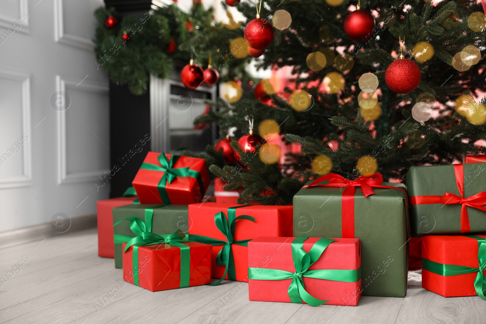 Photo of Beautifully wrapped gift boxes under Christmas tree indoors