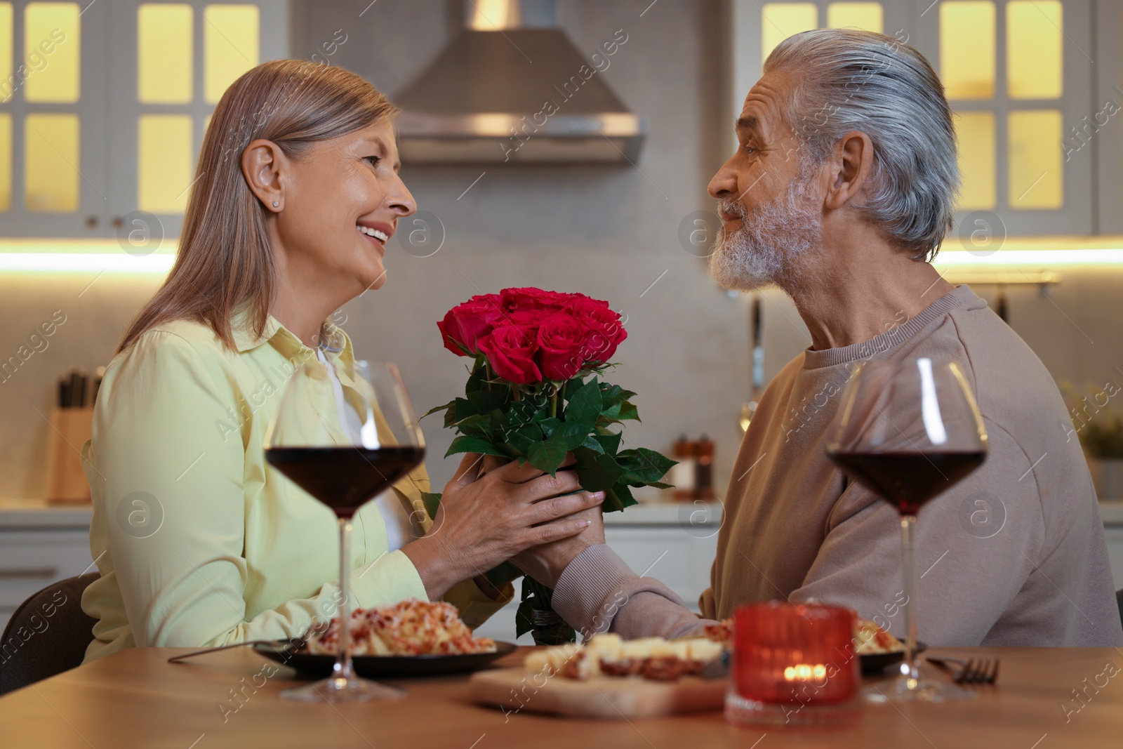 Photo of Affectionate senior couple having romantic dinner at home