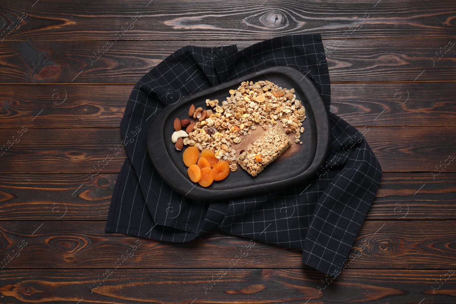 Photo of Tasty granola bar and ingredients on wooden table, top view