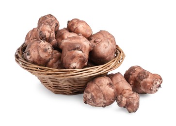 Photo of Wicker basket and many Jerusalem artichokes isolated on white