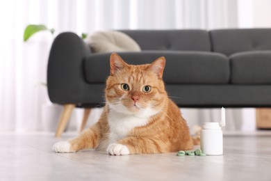 Photo of Cute ginger cat and vitamin pills indoors