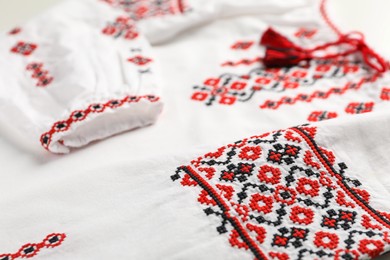 Photo of Beautiful white shirt with red Ukrainian national embroidery, closeup