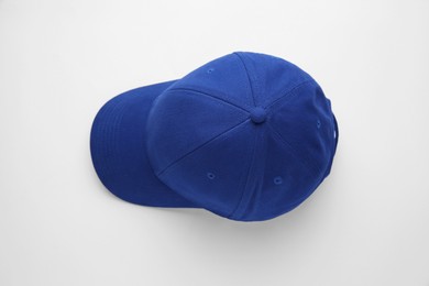 Photo of Stylish blue baseball cap on white background, top view