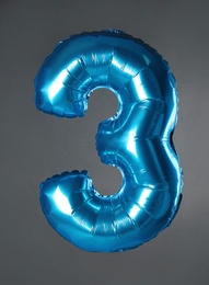 Photo of Blue number three balloon on grey background