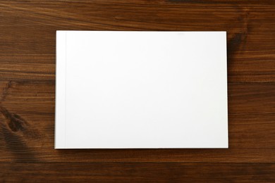 Photo of Blank paper brochure on wooden table, top view. Mockup for design