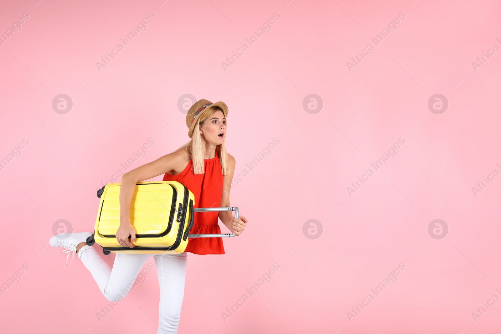 Photo of Woman with suitcase running on color background. Space for text