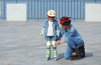 Photo of Mother and her daughter wearing roller skates on city street