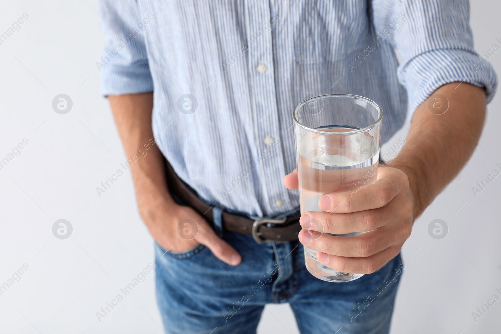 Photo of Man holding glass of pure water on white background, closeup