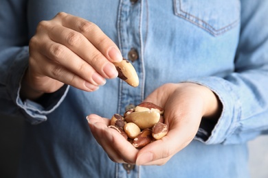 Woman holding delicious Brazil nuts, closeup view