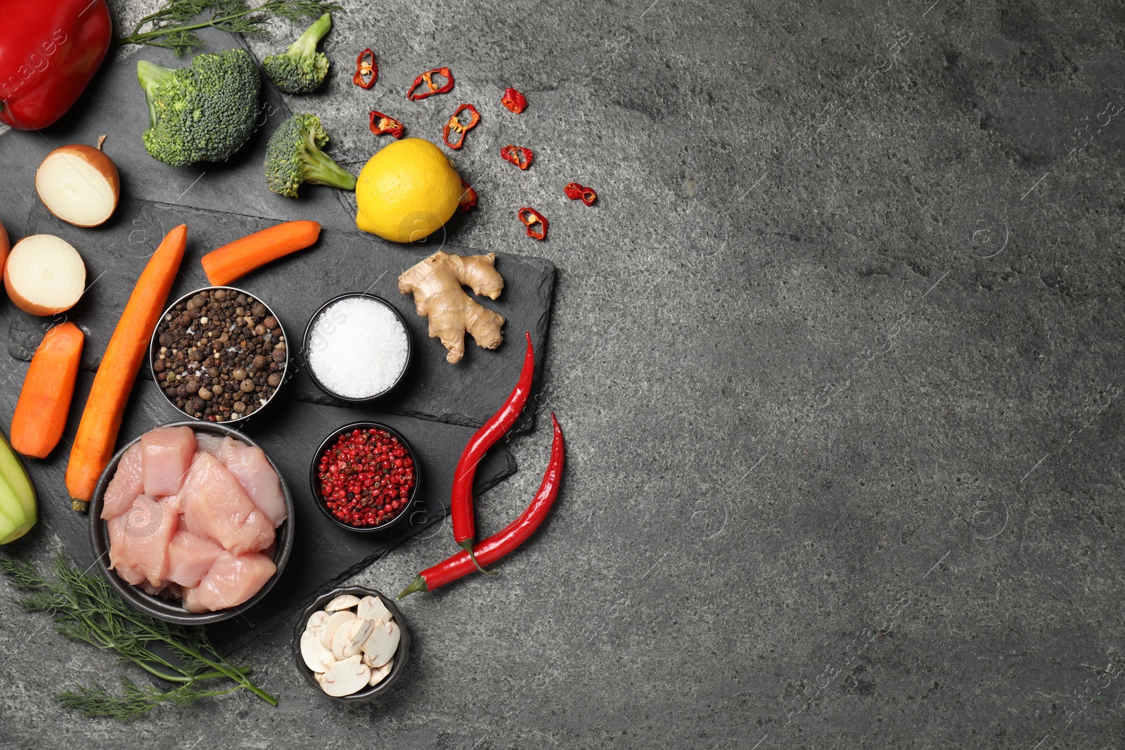 Photo of Different raw products and spices on grey table, flat lay. Space for text