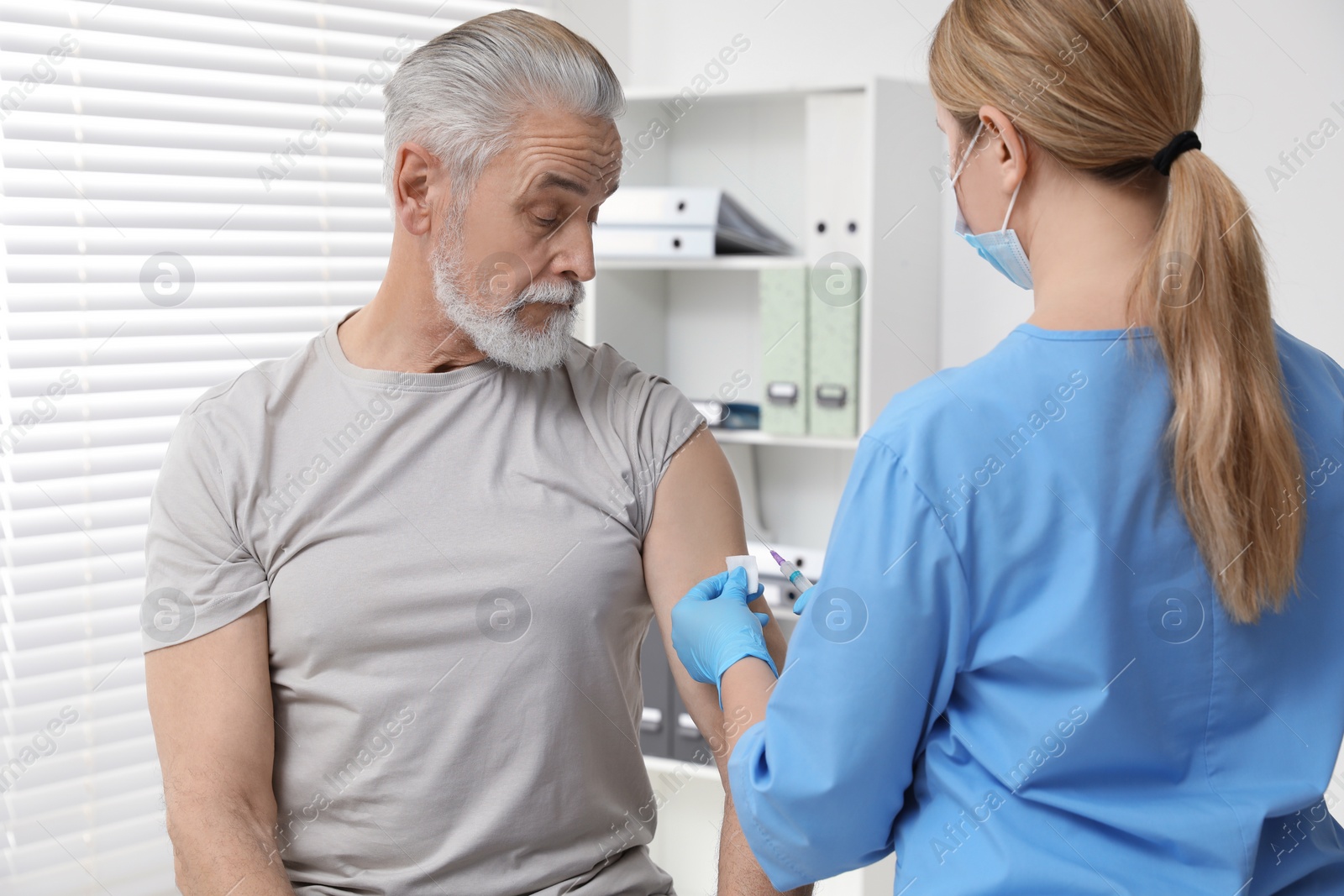 Photo of Doctor giving hepatitis vaccine to patient in clinic