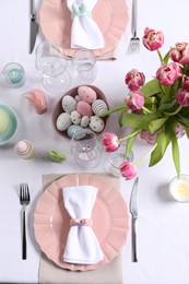 Photo of Festive table setting with beautiful flowers, flat lay. Easter celebration