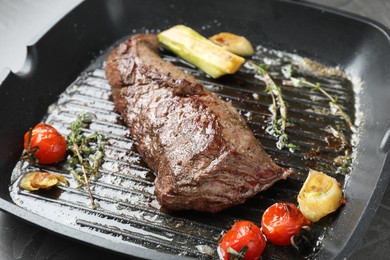 Photo of Delicious grilled beef meat and vegetables in pan on table, closeup