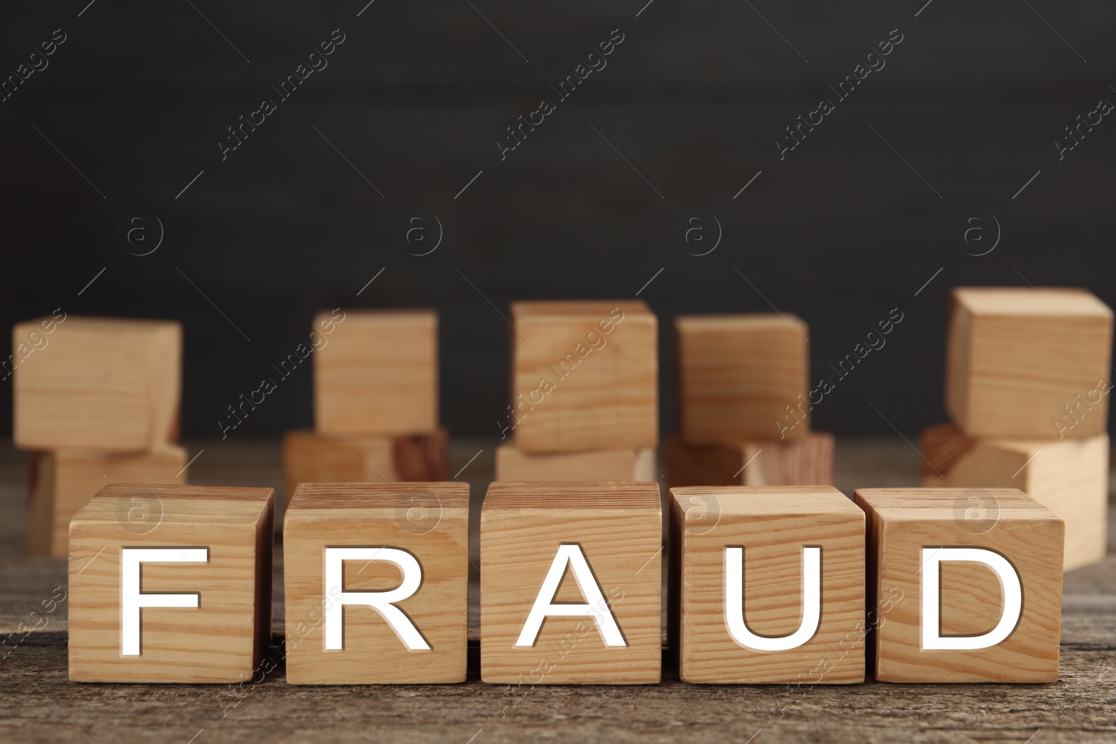 Photo of Wooden cubes with word Fraud on table, space for text