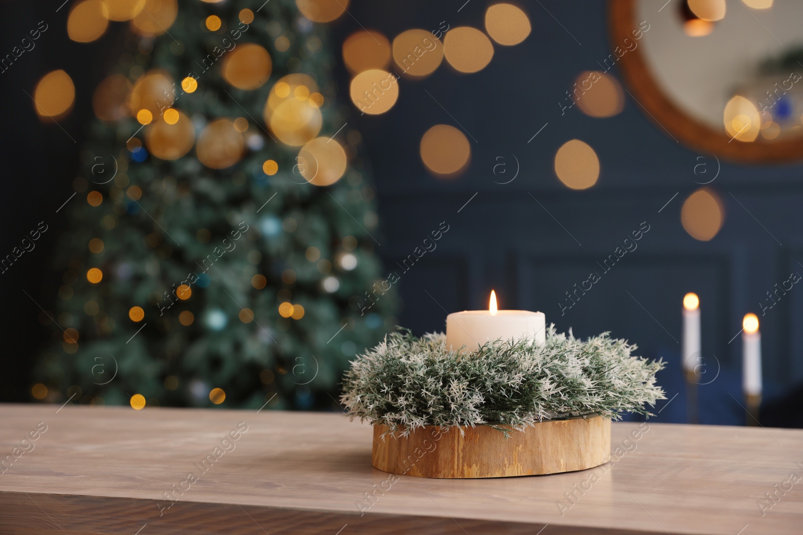 Photo of Beautiful burning candle with Christmas decor on wooden table, space for text