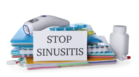 Photo of Card with phrase STOP SINUSITIS, non-contact thermometer and different drugs on white background