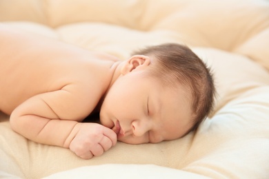 Adorable newborn baby sleeping on bed