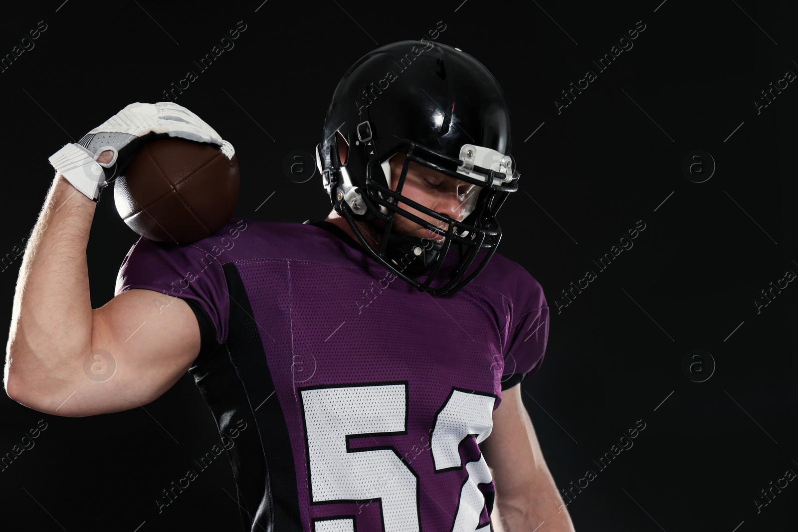 Photo of American football player with ball on dark background