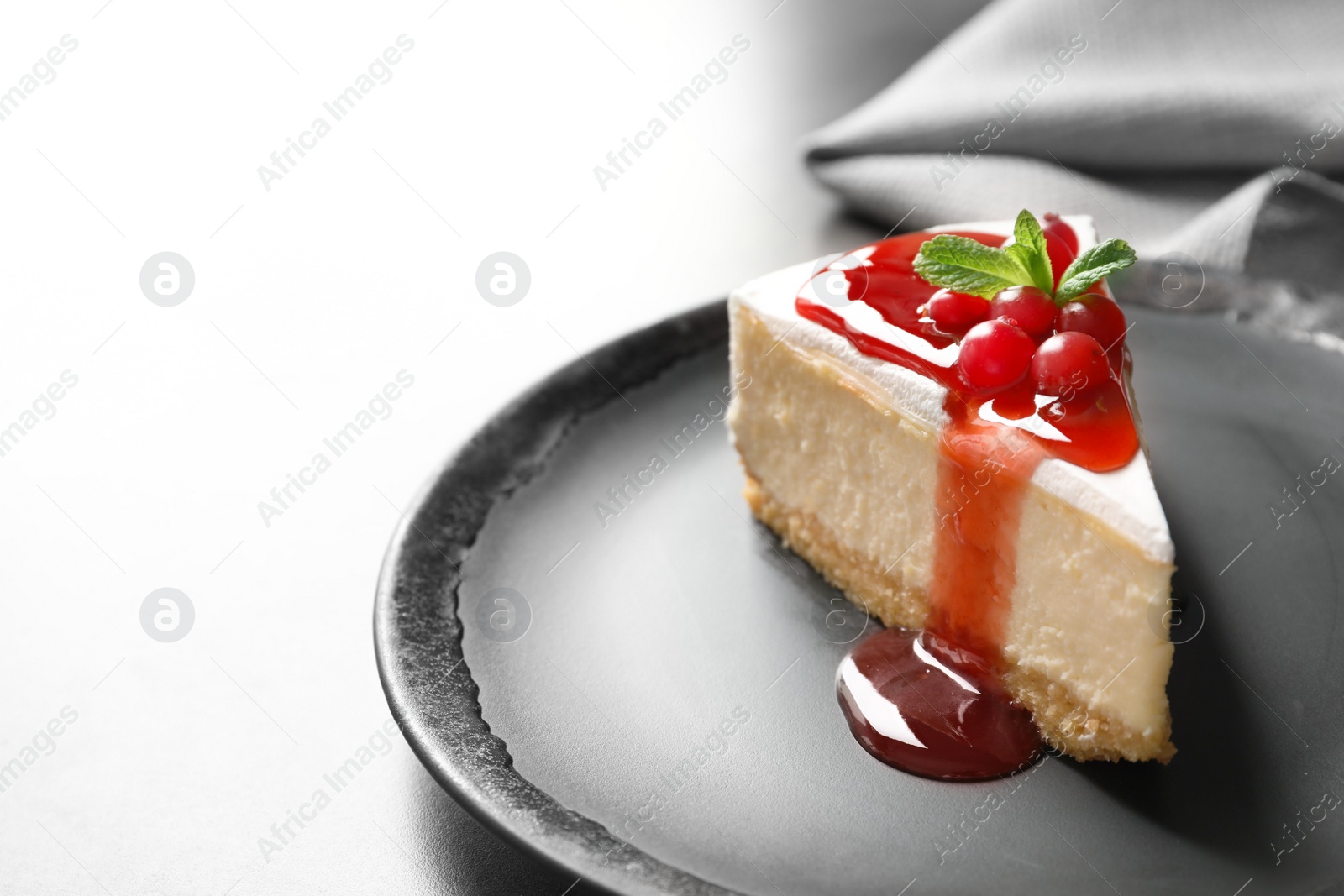 Photo of Delicious cheesecake served with sweet jam on plate