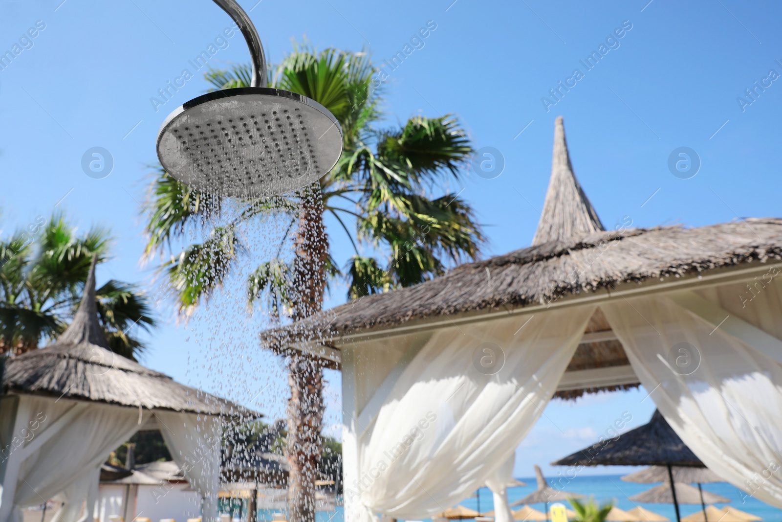 Photo of Outdoor shower with running water on beach at resort