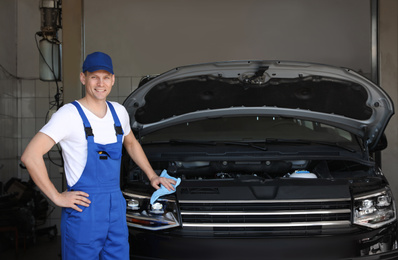 Photo of Professional auto mechanic near modern car in service center