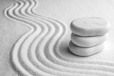 Photo of Stack of white stones on sand with pattern, space for text. Zen, meditation, harmony