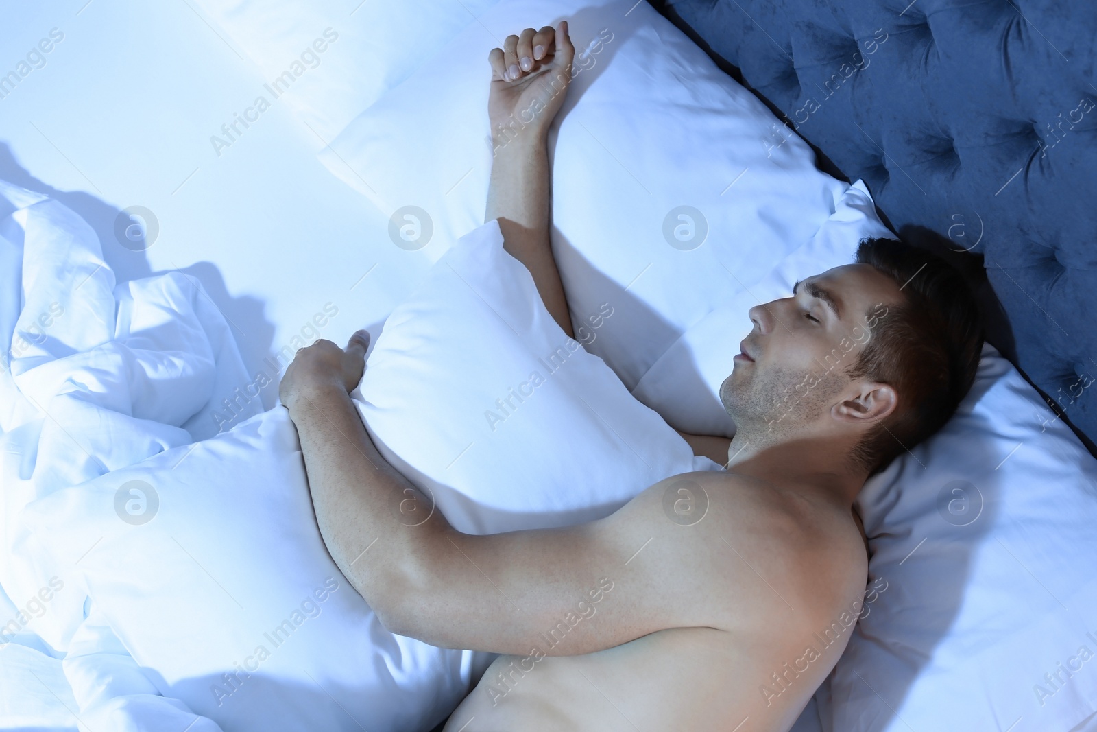 Photo of Young man sleeping in bed at night