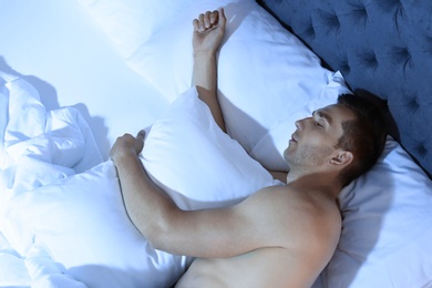 Young man sleeping in bed at night