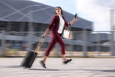 Image of Being late. Businesswoman with suitcase and ticket running at station. Motion blur effect