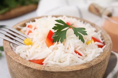 Photo of Bowl of delicious rice with vegetables and parsley, closeup