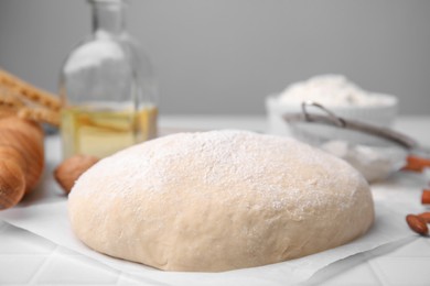 Fresh dough and ingredients on white table, closeup