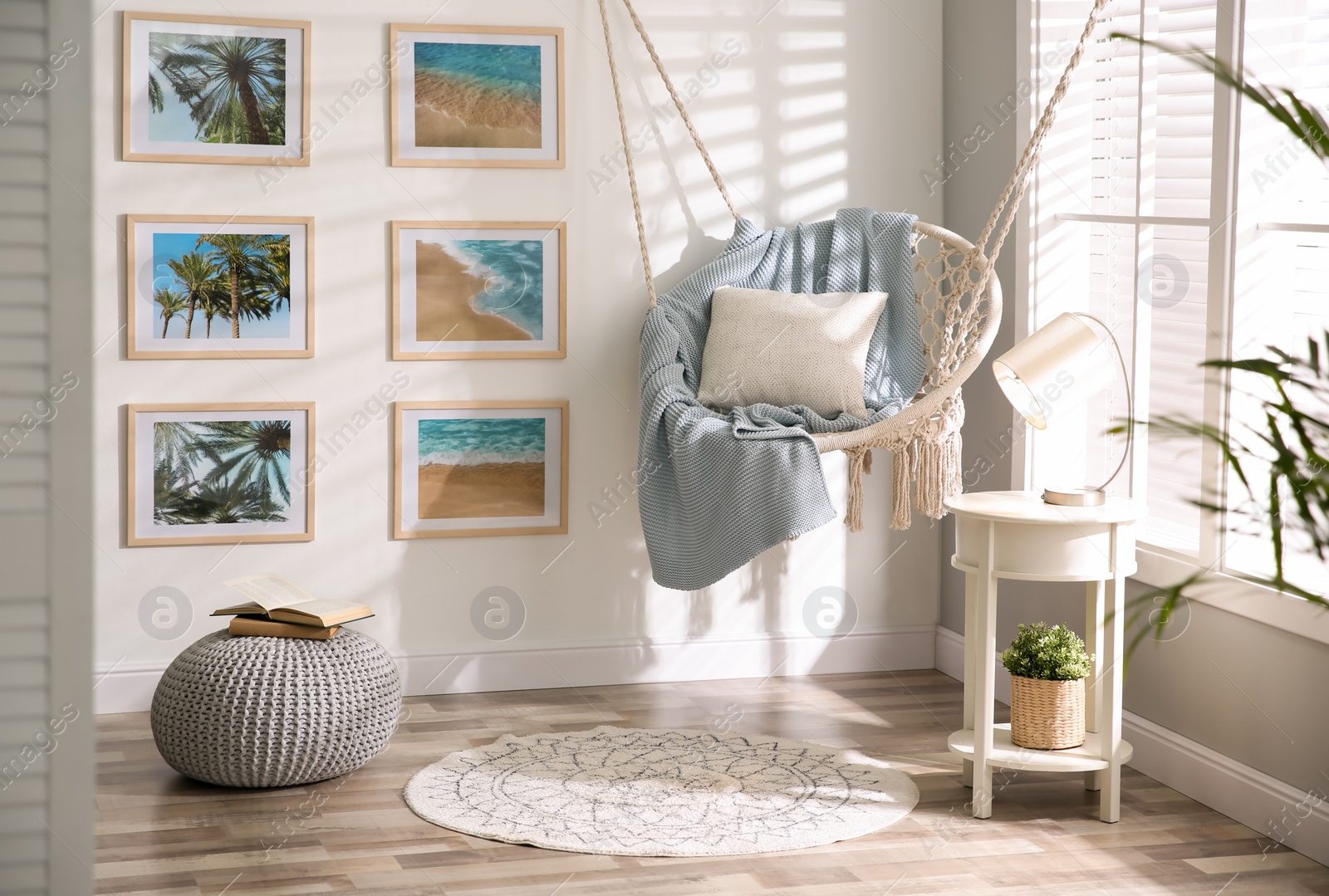 Photo of Stylish room interior with artworks and hanging chair