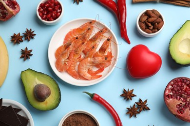 Photo of Natural aphrodisiac. Different food products and red decorative heart on light blue background, flat lay