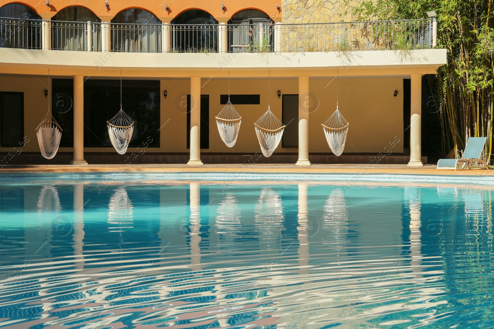 Photo of Hotel building with hammock and clean pool outdoors