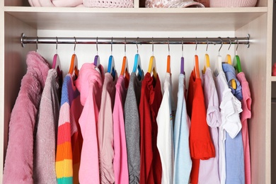 Photo of Wardrobe with stylish girl's clothes hanging on rack