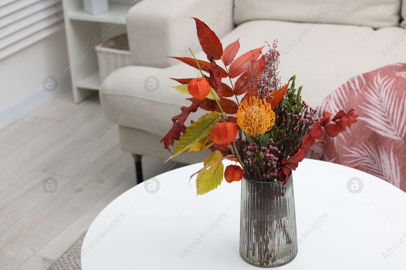 Photo of Vase with bouquet of dry flowers and leaves on side table indoors, space for text