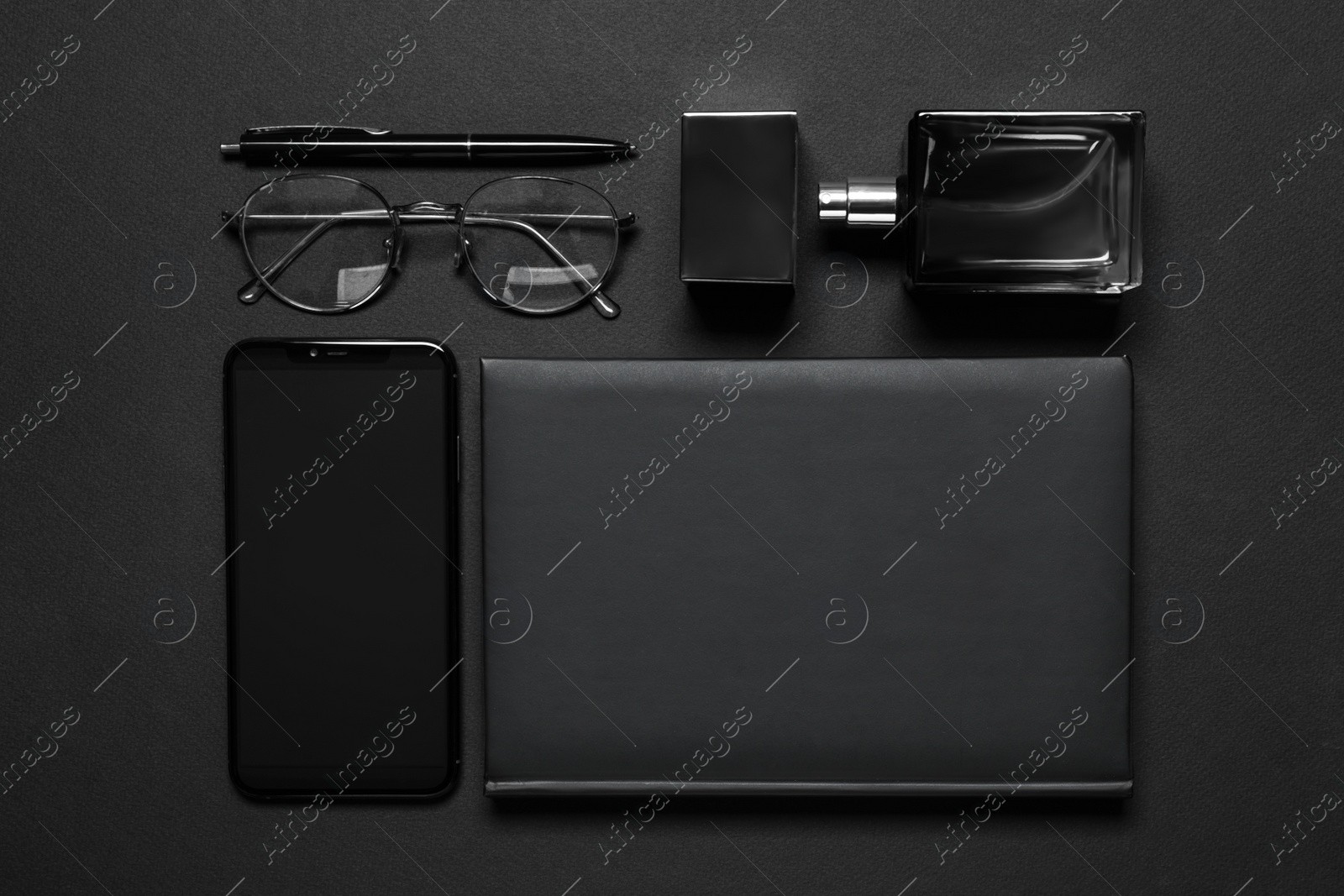 Photo of Flat lay composition with male accessories and smartphone on black background