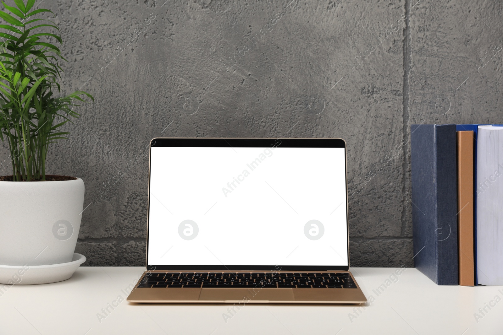 Photo of Workplace with modern laptop on white table. Mockup for design