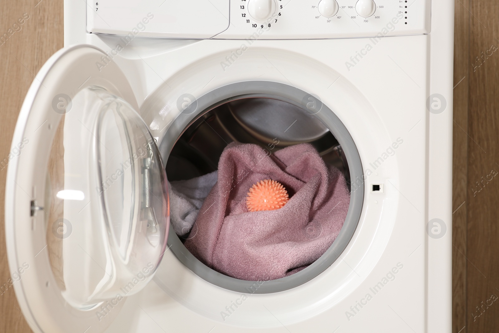 Photo of Dryer ball and towels in washing machine, closeup