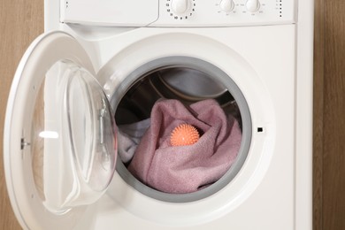 Dryer ball and towels in washing machine, closeup