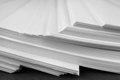 Photo of Stack of blank paper on grey stone table, closeup