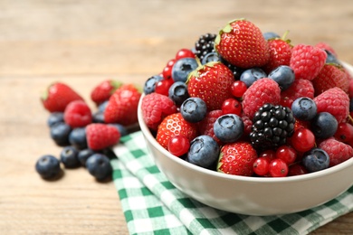 Photo of Mix of ripe berries on wooden table, closeup