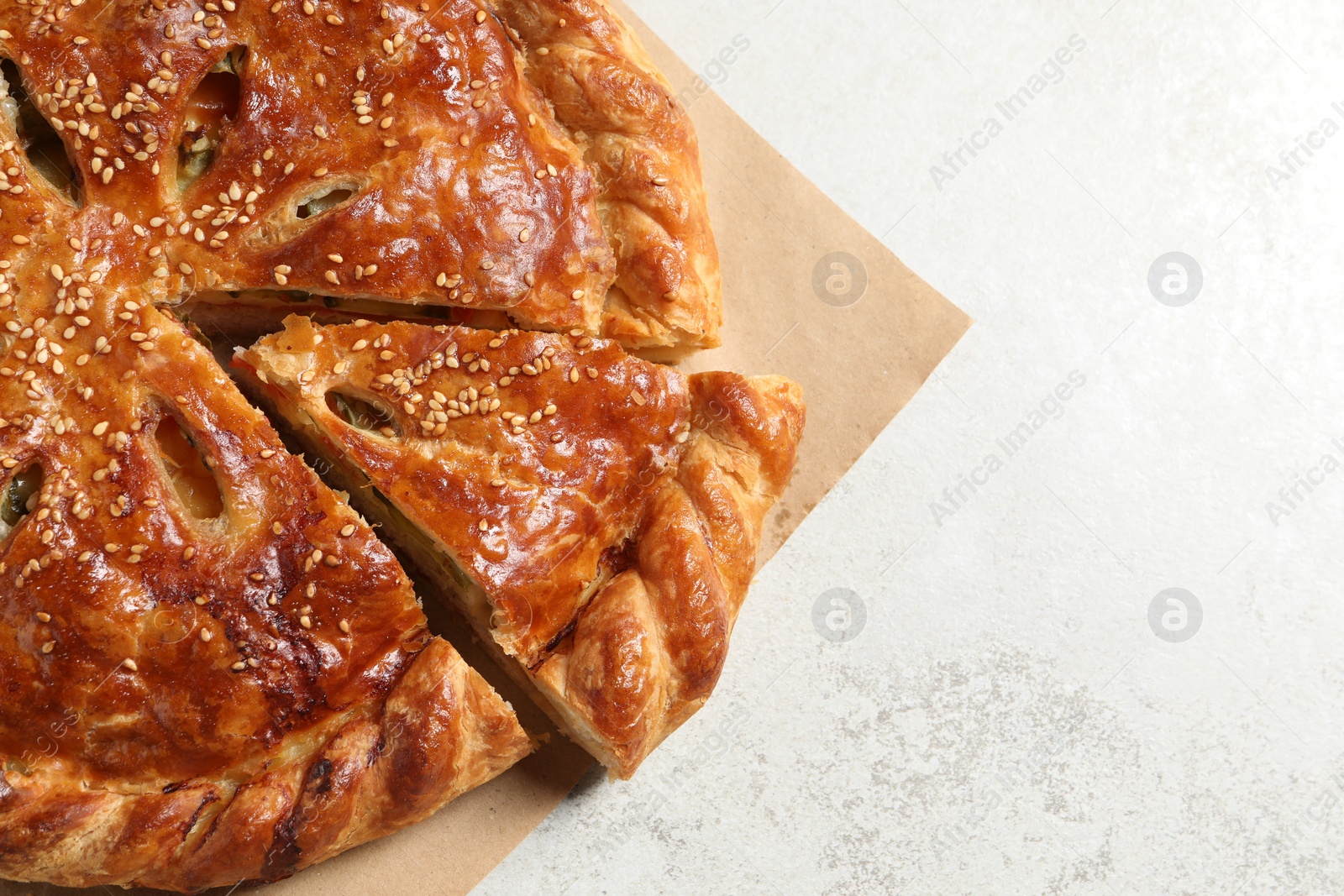 Photo of Cut delicious homemade pie on light grey table, top view. Space for text