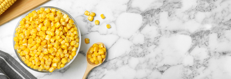 Image of Delicious canned corn in bowl and space for text on marble table, flat lay. Banner design