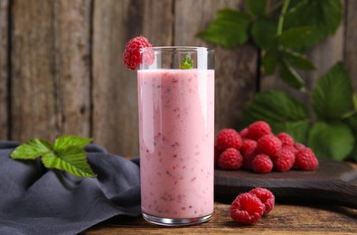 Photo of Glass of tasty fresh raspberry smoothie on wooden table