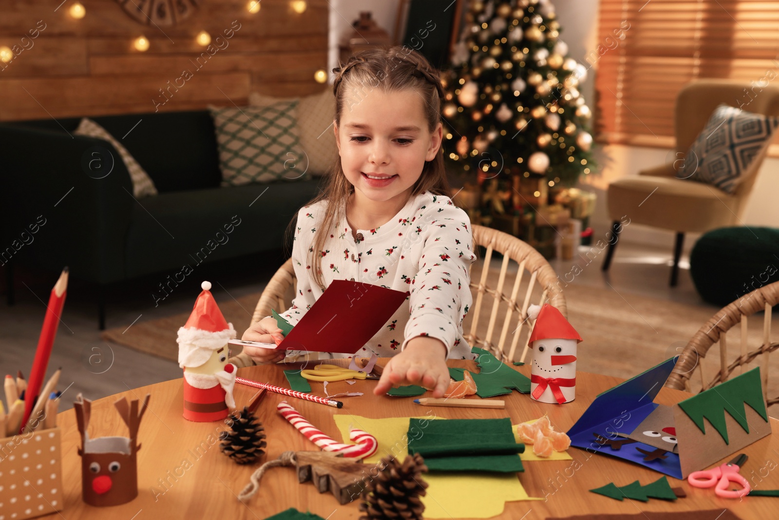 Photo of Cute child making Christmas greeting card at home