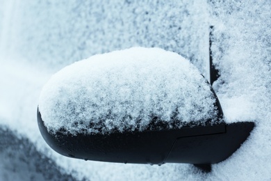 Car rear view mirror covered with snow, closeup